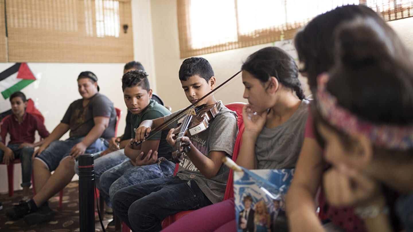Music lessons bring art, hope to refugee camps